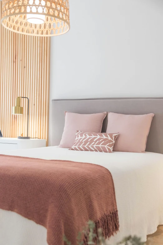 a bedroom with wooden walls and pink throw pillows