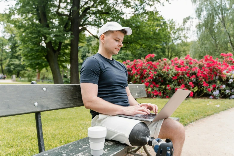 a man sitting on a park bench using a laptop, by Adam Marczyński, prostheses, avatar image, prosthetic, professional image