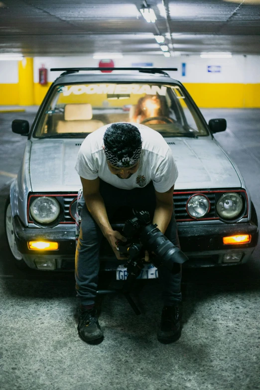 a man sitting on the hood of a car