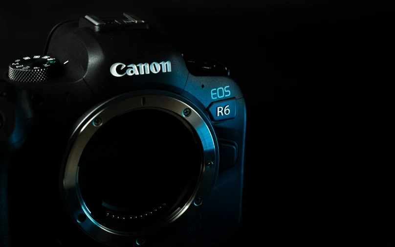 a close up of a camera on a black background, canon eos r 6, blue color grading, photorealistic ”