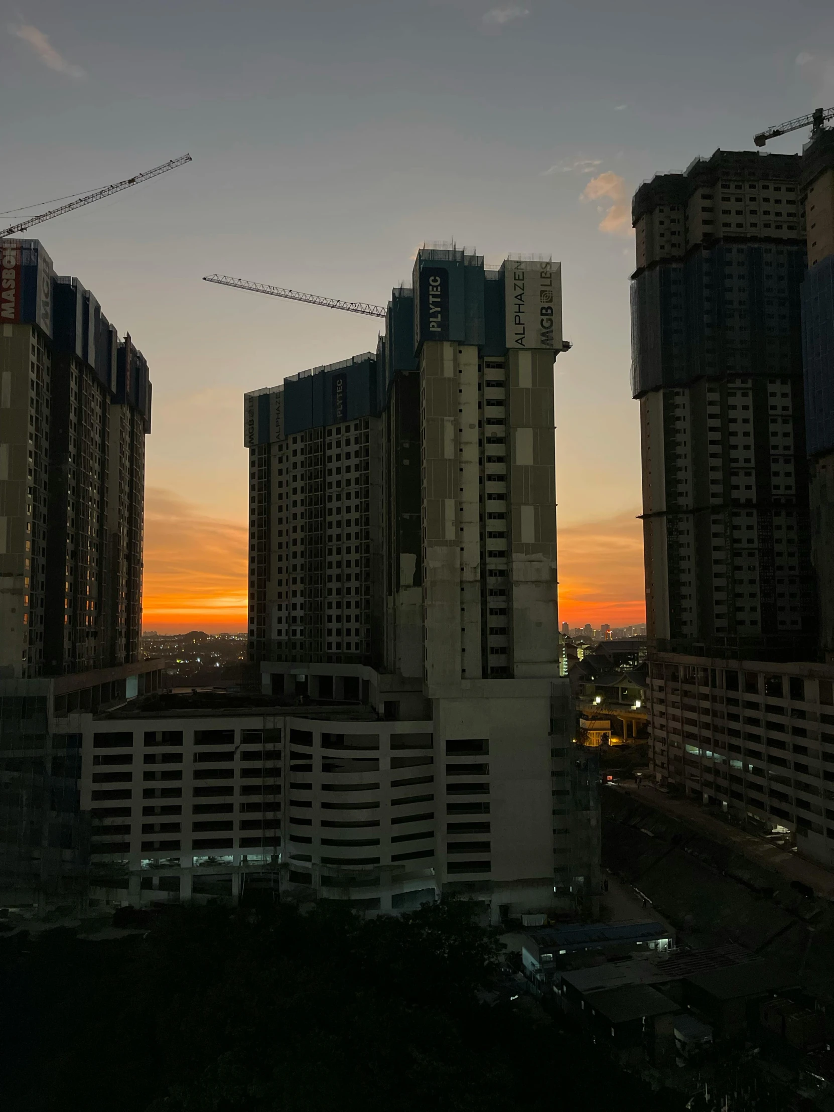 a group of tall buildings sitting next to each other, during a sunset, manila, under construction, full room view