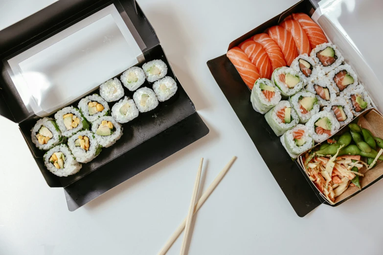 several plates of sushi, chopsticks and a plate with salad