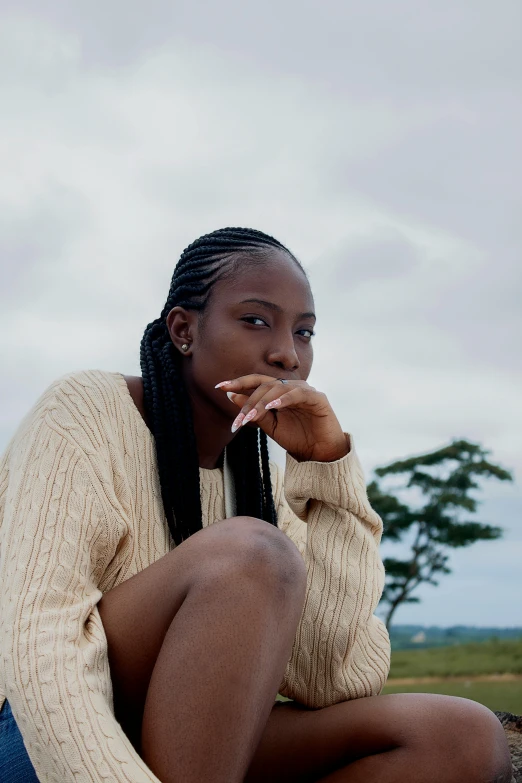 the young black woman is sitting on a pile of dirt