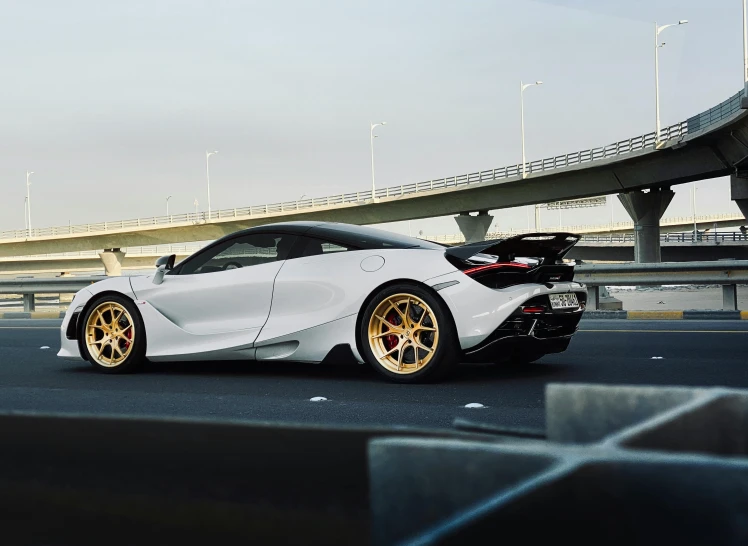 a white toyota sports car with yellow wheels