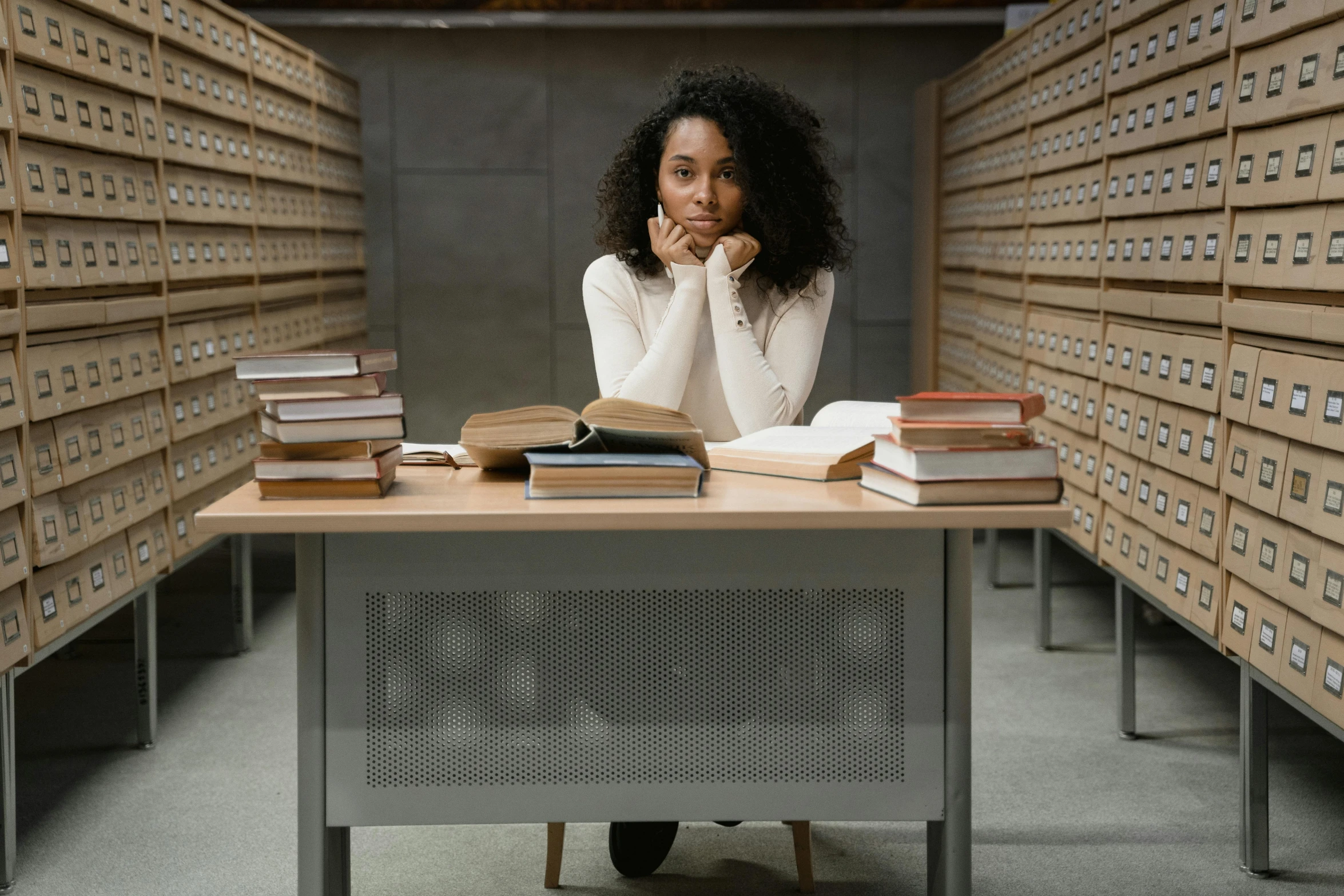 a woman sitting at a desk in a library, pexels, bored, black young woman, unedited, scientific research