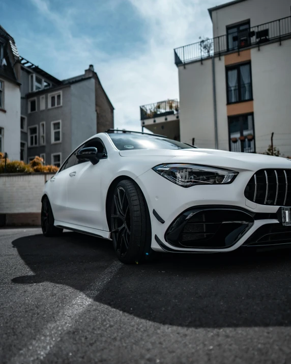 the front end of a mercedes cla parked on a road in a city