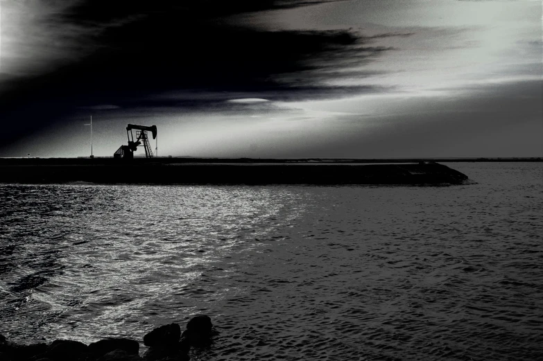 a black and white photo of a large body of water, inspired by Chris Friel, pexels contest winner, oilfield scene, peaceful evening harbor, ilustration, surrealism - n 9