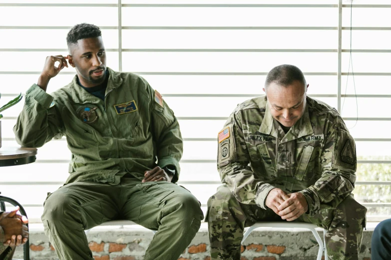 a couple of men sitting next to each other, pexels, hurufiyya, air force jumpsuit, very emotional, wearing a military uniform, dialogue