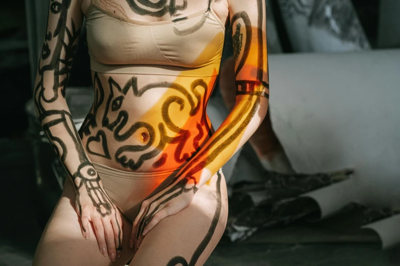 a woman with a tattoo on her body, inspired by Elsa Bleda, trending on pexels, graffiti, body full glowing vacuum tubes, an anthropomorphic stomach, thigh skin, tribal paint