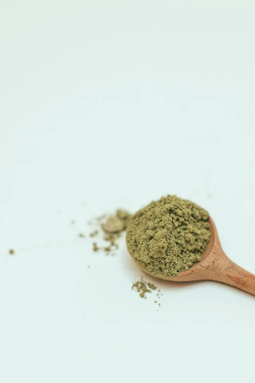 a wooden spoon filled with green powder on top of a white surface, a picture, unsplash, renaissance, marihuana, thumbnail, small in size, tall