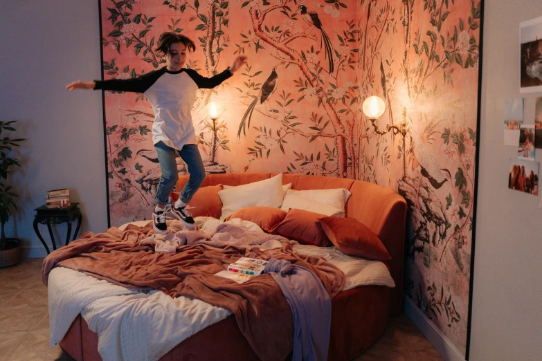 a young lady is jumping on her bed