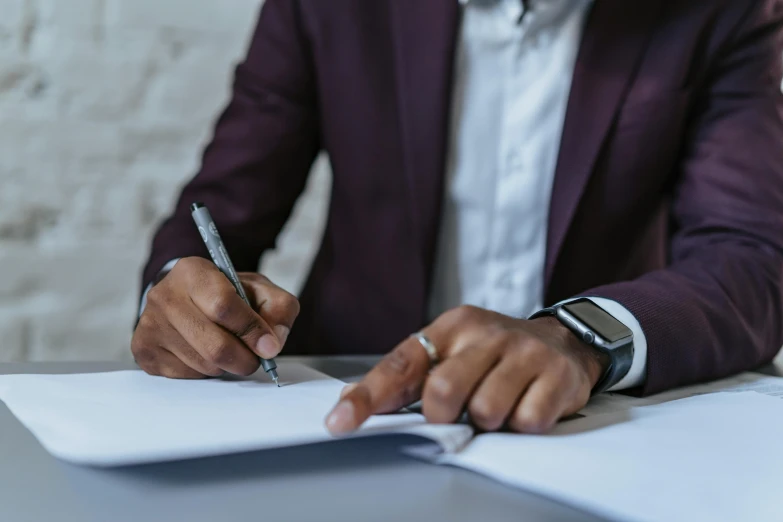 a man in suit writing in a notebook