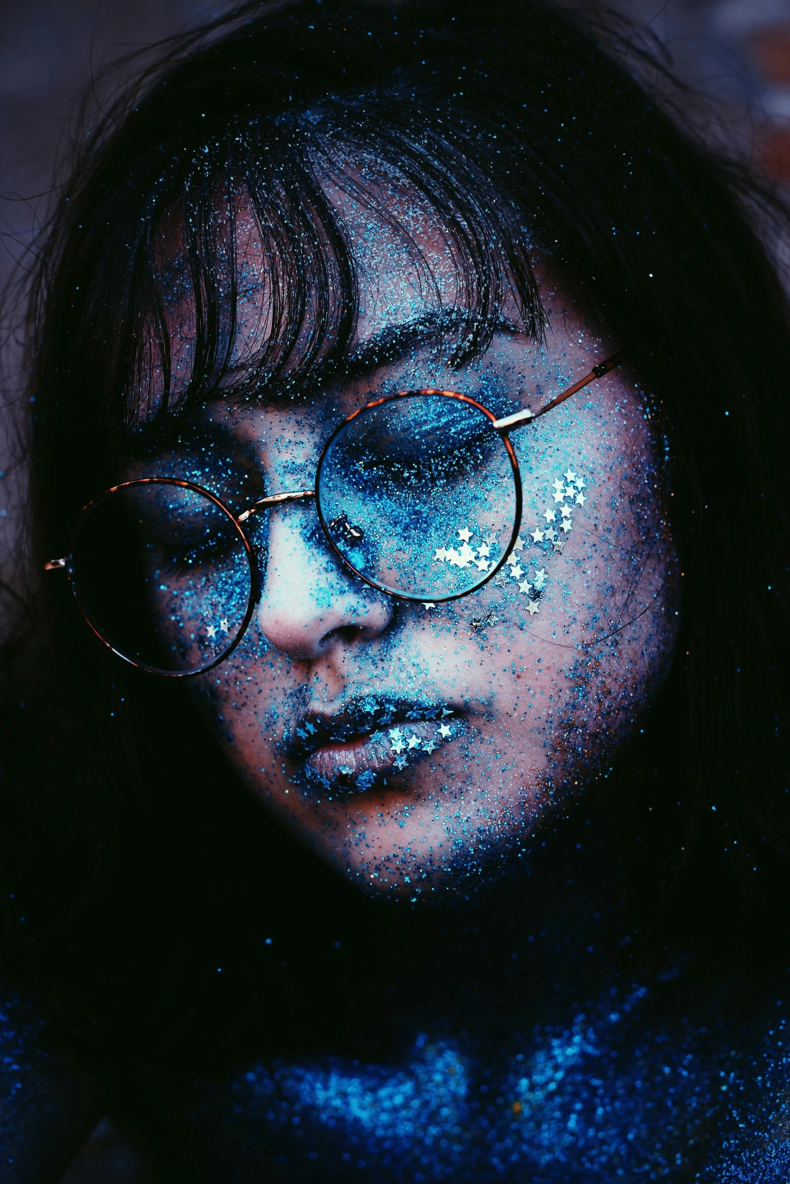 a woman with glitter on her face and glasses, an album cover, inspired by Elsa Bleda, trending on pexels, holography, blue fireflies, stippling dots, 33mm photo, grainy quality