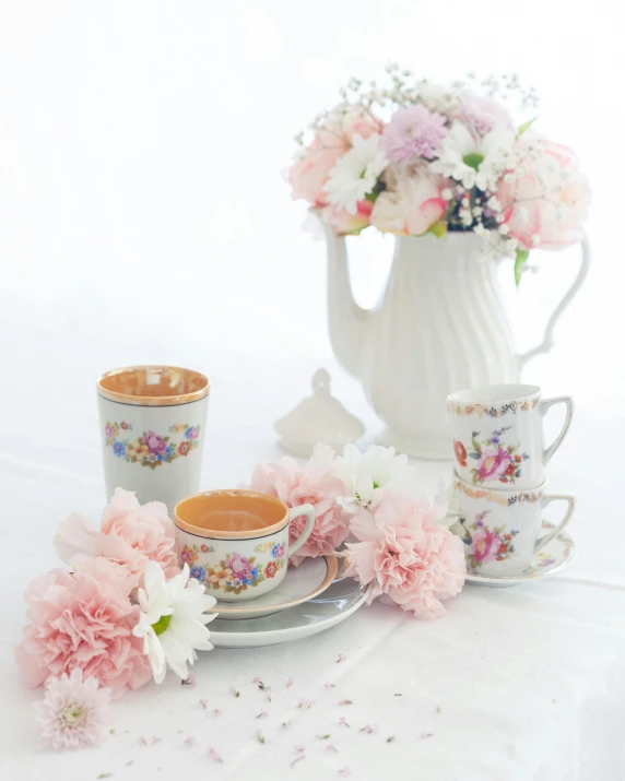 a table topped with a white vase filled with flowers, drinking tea, set against a white background, lots of pastel colour, promo image