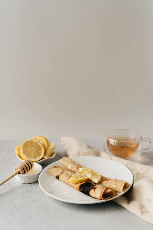 a plate full of sliced bananas next to a cup of honey