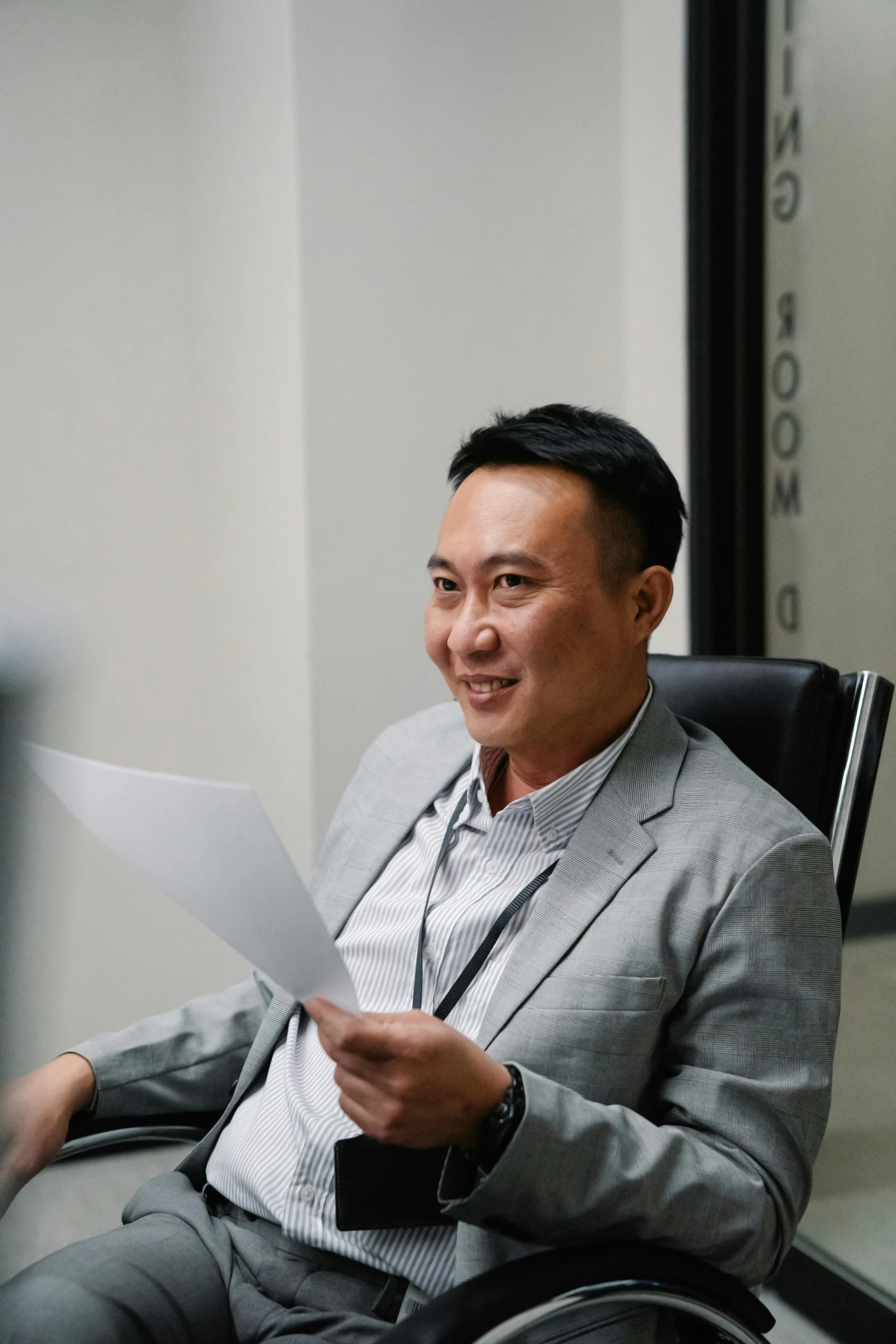 the man smiles as he sits in front of a computer