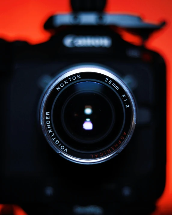 a close up of a camera with a red background, pexels contest winner, wide angle lens glow in the dark, looking into camera, canon macro lens, picture