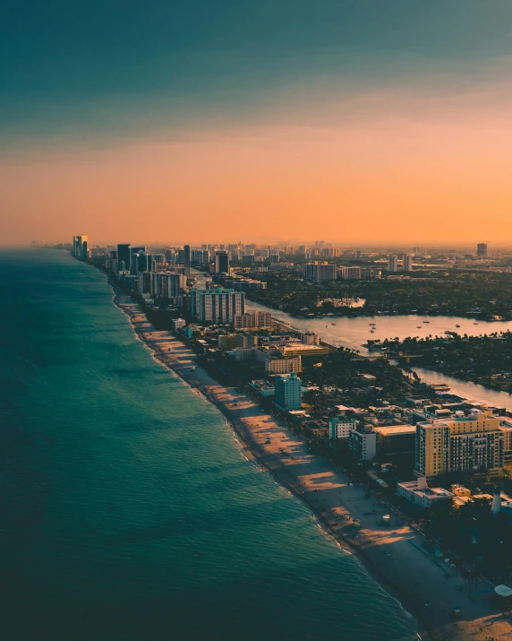 a large body of water next to a beach, by Seb McKinnon, pexels contest winner, renaissance, vice city, lgbtq, entire city in view, late afternoon