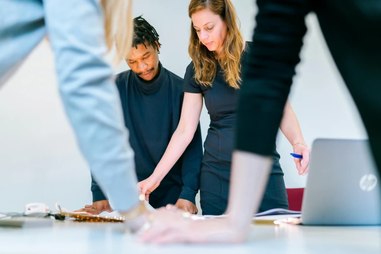 a group of people standing around a table with a laptop, by Nina Hamnett, trending on unsplash, performance, artsationhq, profile image, university