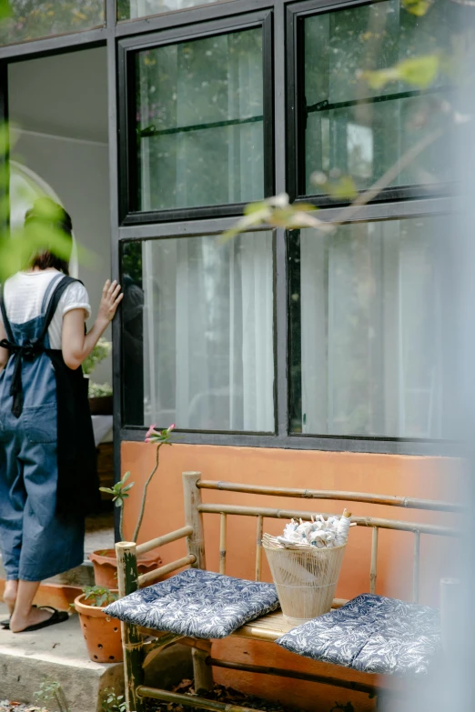a couple of people standing in front of a house, by Julia Pishtar, unsplash, happening, wearing maid uniform, looking outside, gardening, vietnamese woman