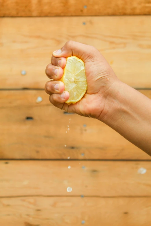 a person holding a lemon and drops it with soap