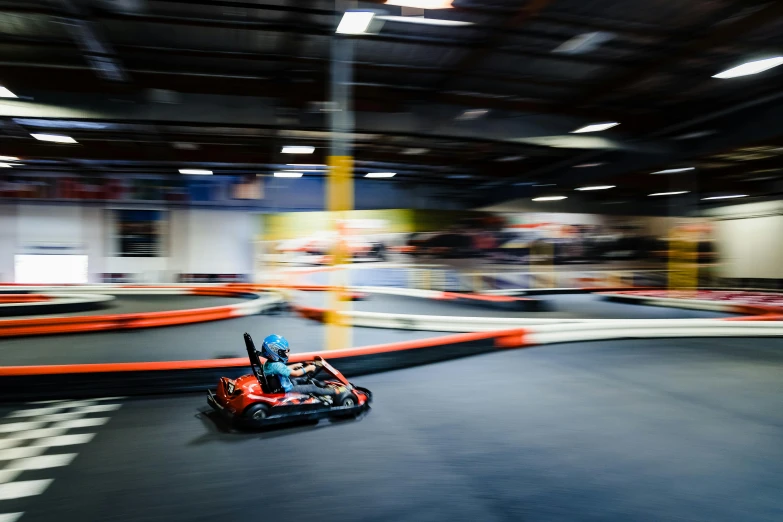 people riding their kart - racing vehicles around the track