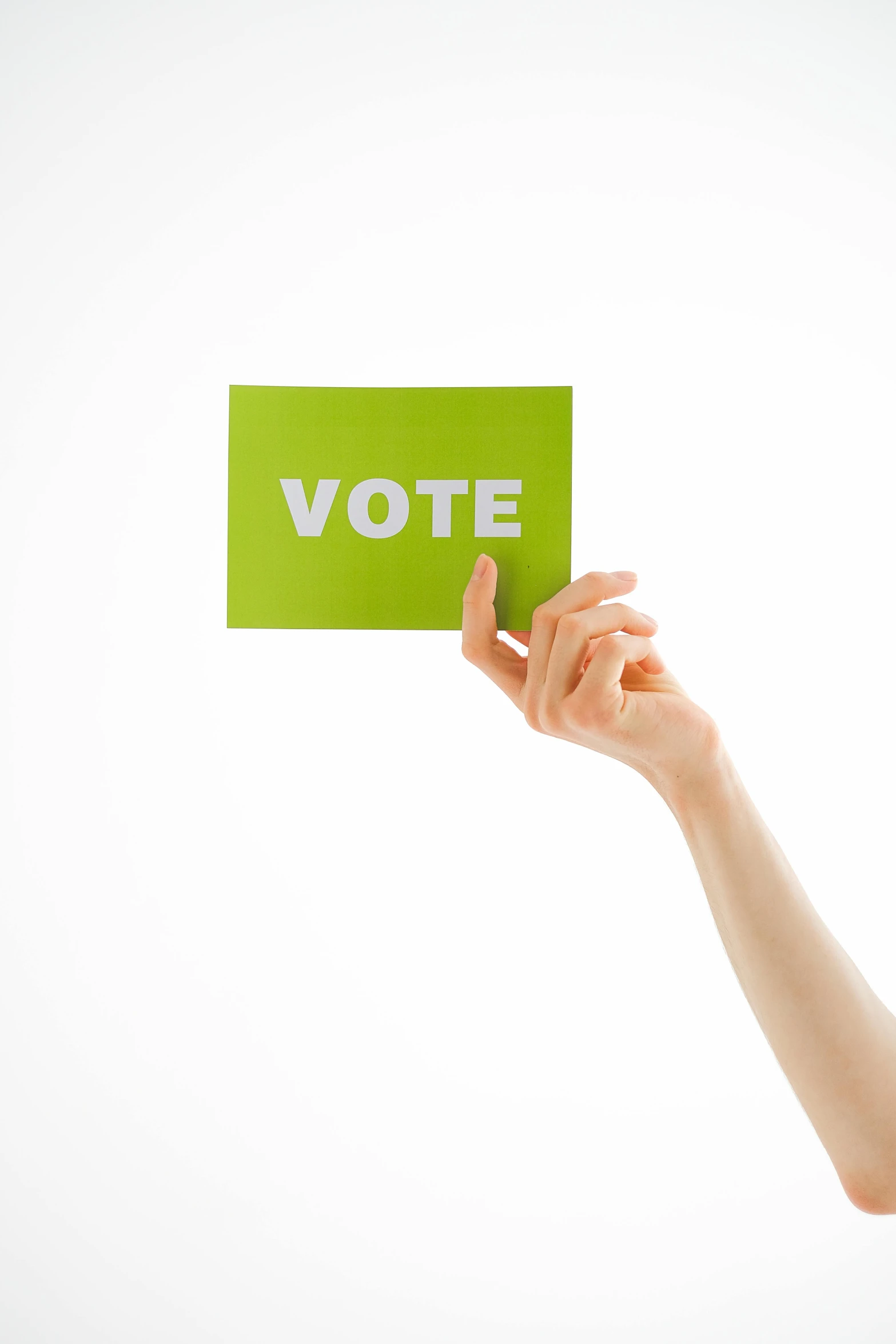 a person's hand holding up a sign that reads vote