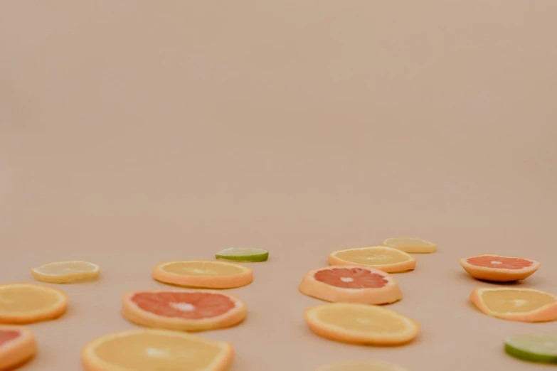 a table topped with slices of oranges and limes, trending on pexels, minimal pink palette, slight haze, c 4 d style, background image