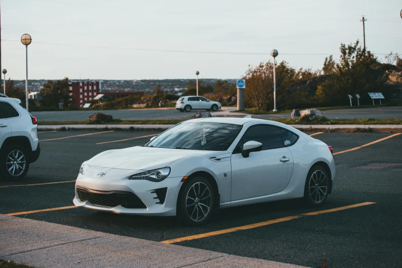two white sports cars parked in a parking lot