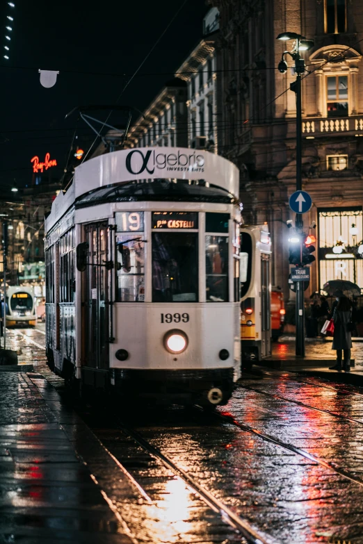 a trolley on a city street at night, pexels contest winner, art nouveau, white, italian, wet streets, square