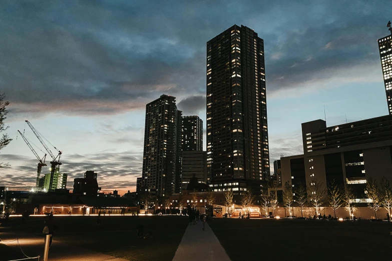 a couple of tall buildings sitting next to each other, by Niko Henrichon, unsplash contest winner, visual art, late evening, nanae kawahara, a park, slight overcast lighting