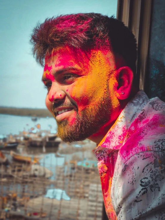 a man with red and yellow paint on his face, a colorized photo, pexels contest winner, color field, hindu aesthetic, a still of a happy, scruffy looking, colorful scene