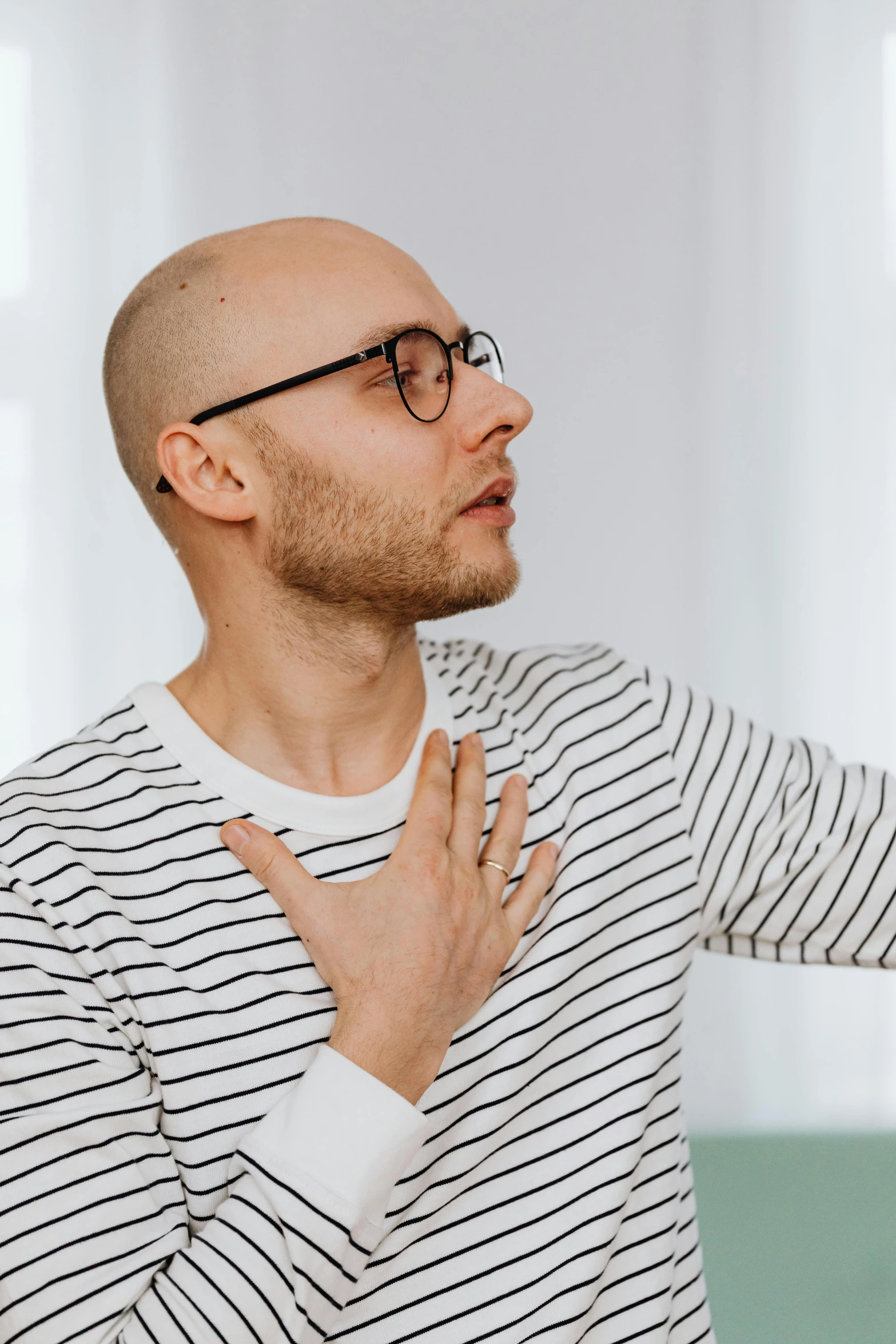 a man taking a selfie with his cell phone, by Adam Marczyński, trending on pexels, romanticism, heart emblem on chest, portrait of bald, respiratory flap, wearing stripe shirt