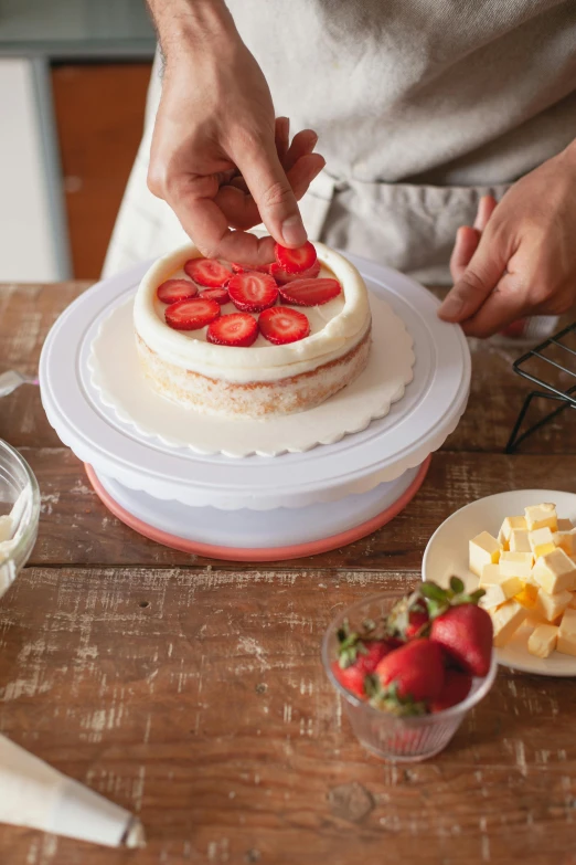 a person putting strawberries on top of a cake, silicone cover, miko, multi-part, airy