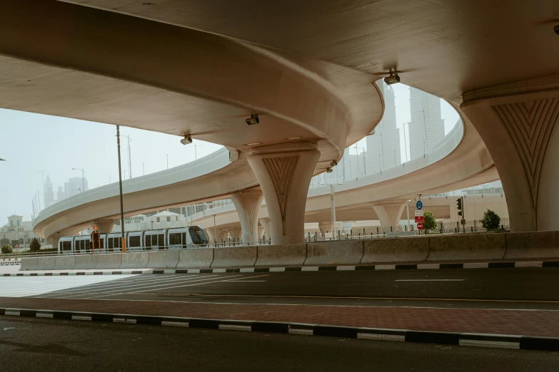 a city street filled with lots of traffic under a bridge, inspired by Zaha Hadid, pexels contest winner, hyperrealism, dubai, rounded ceiling, city in desert, bus station