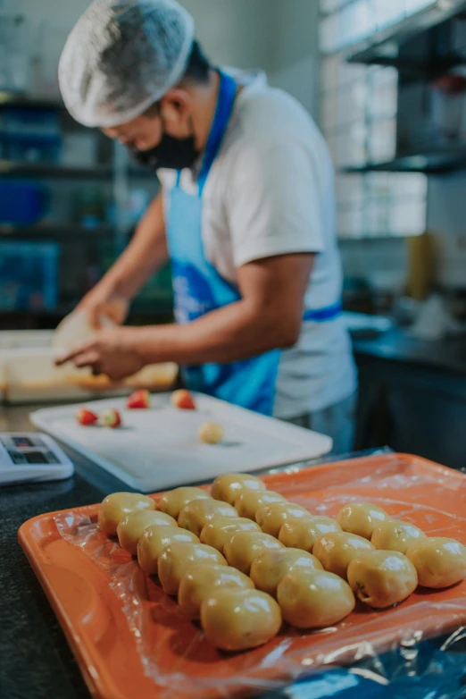 a man in a kitchen preparing food on a cutting board, fresh bakeries in the background, lots of mozzarella balls, colombian, profile image