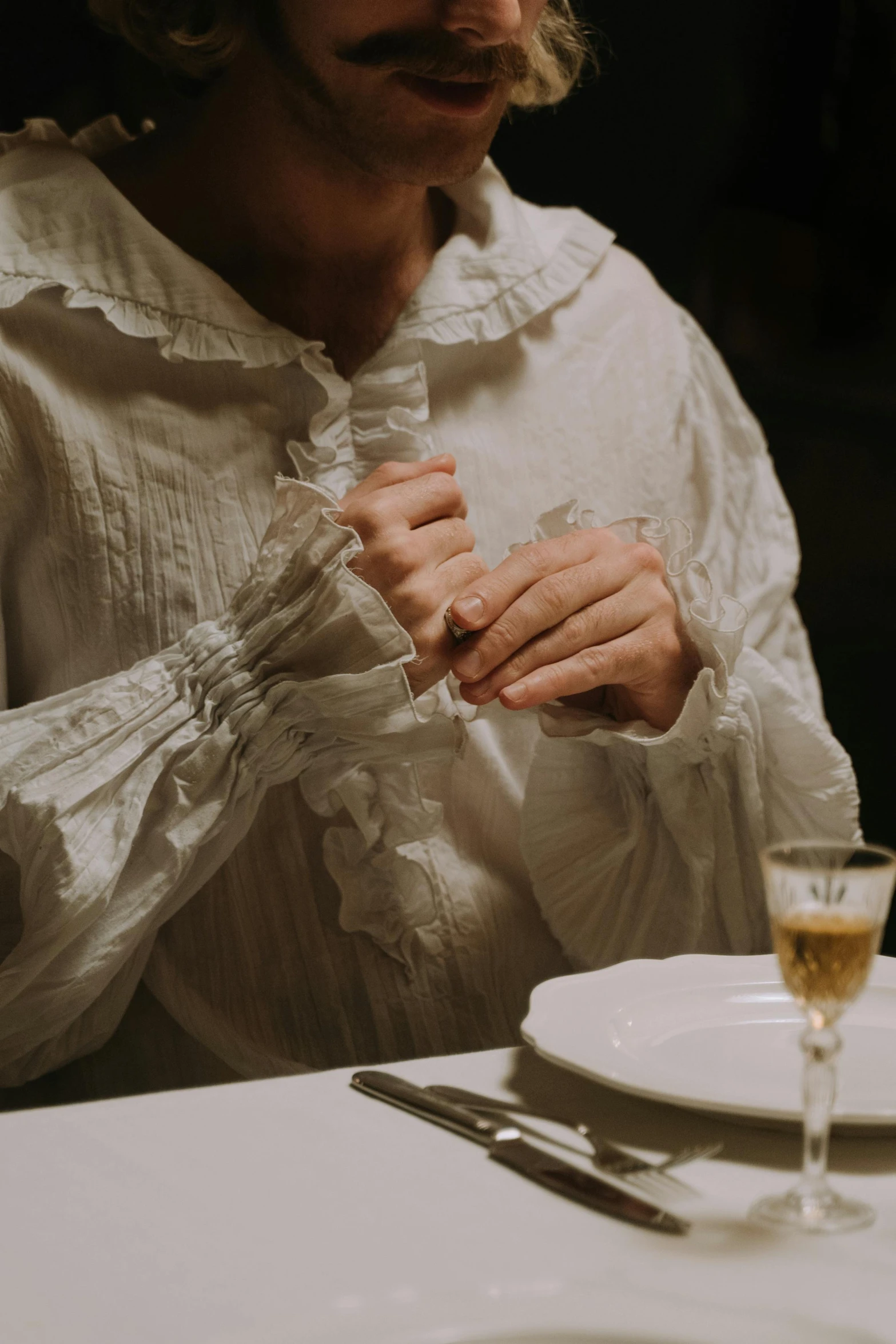 woman holding on to her tie over a glass of wine