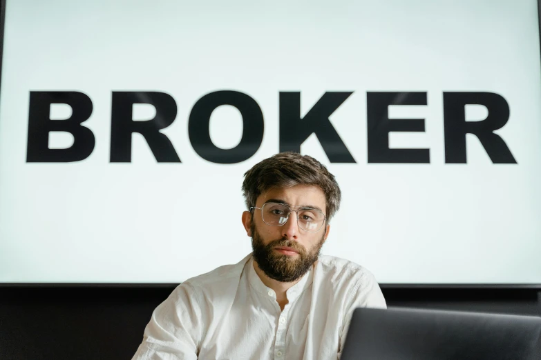 a man sitting in front of a laptop computer, by Bertram Brooker, pexels contest winner, hyperrealism, broken signs, acronym, brook, ceo