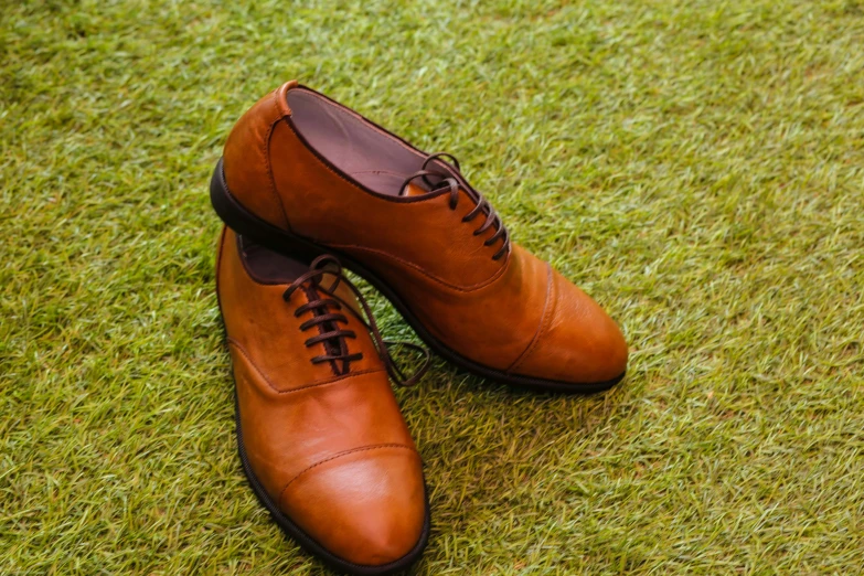 a pair of tan shoes on the grass