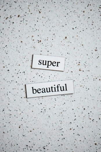 a piece of paper with the words super beautiful on it, by Sophia Beale, trending on pexels, superflat, concrete poetry, smooth porcelain skin, grey, beautiful labels
