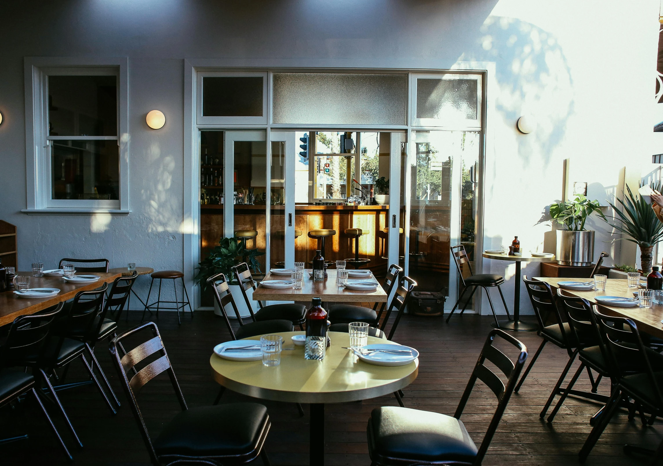 an empty restaurant has two tables and black chairs