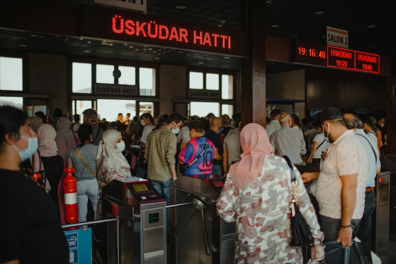 a group of people standing next to each other at an airport, by Matija Jama, pexels, hurufiyya, located in hajibektash complex, batik, train station in summer, exiting store