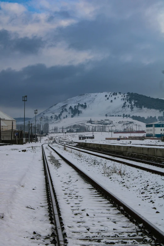 some train tracks covered in snow on a hill