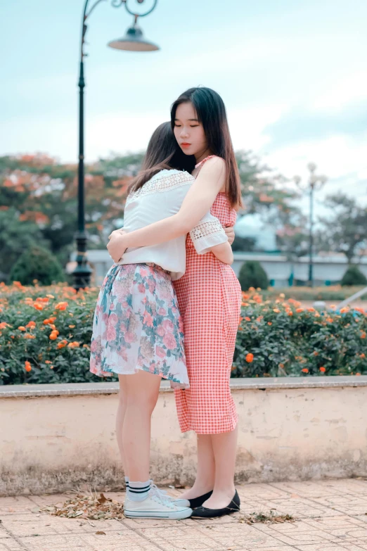 a couple of women standing next to each other, a picture, by Tan Ting-pho, unsplash, realism, teen girl, 15081959 21121991 01012000 4k, hugging, wearing in a summer dress