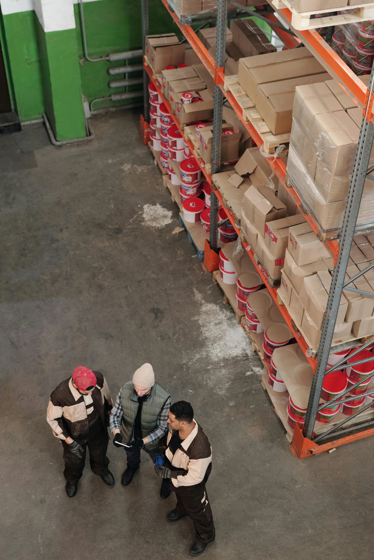 a group of men standing next to each other in a warehouse, by Jang Seung-eop, birdseye view, large jars on shelves, coworkers, cement