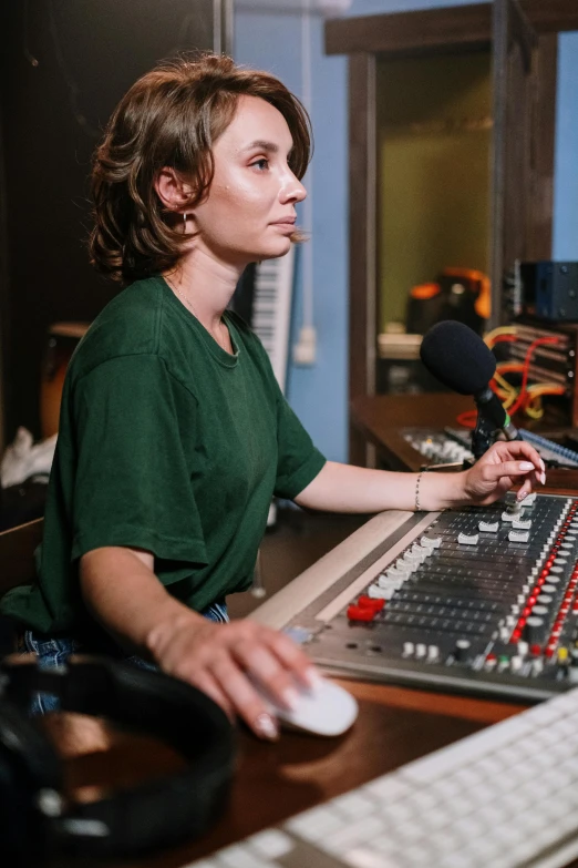 a woman sitting at a desk in front of a computer, a portrait, by Lee Loughridge, pexels, happening, radio equipment, music show, avatar image, finely textured