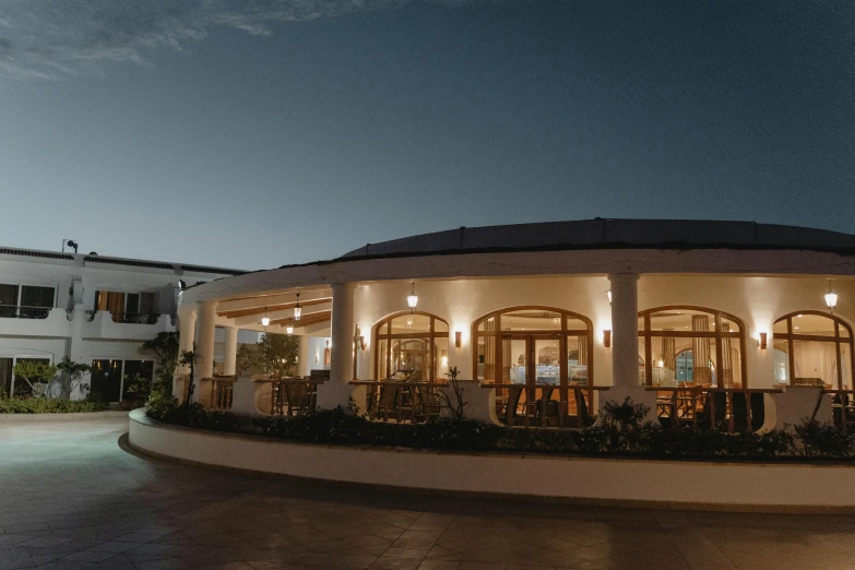 an open building on a cloudy night with lights and a fountain