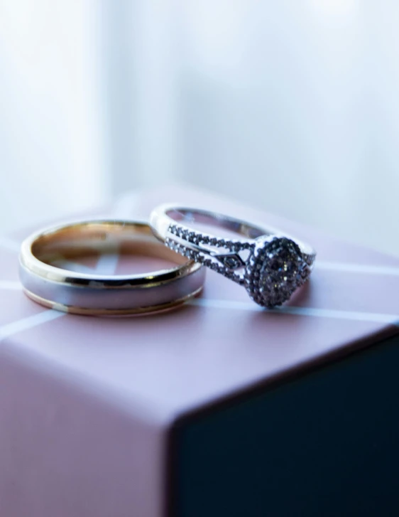 a couple of wedding rings sitting on top of a pink box, a picture, by Joe Bowler, unsplash, square, 15081959 21121991 01012000 4k