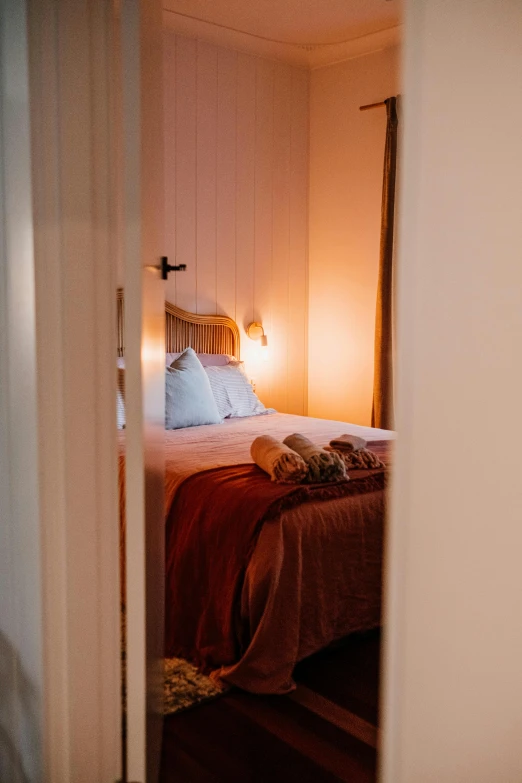 a bed with white sheets and pillows sitting in a small room