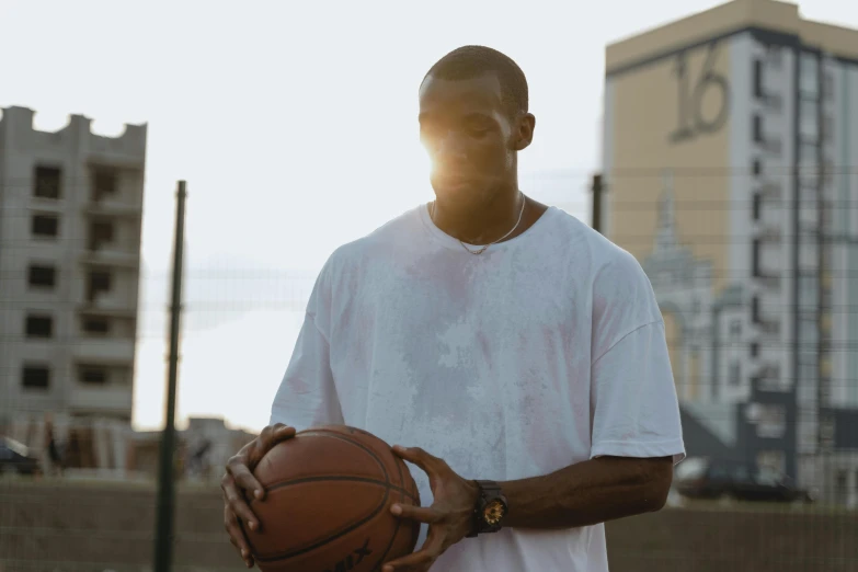a man holding a basketball in his hands, inspired by Paul Georges, pexels contest winner, wearing a watch, low sun, ( ( theatrical ) ), portrait shot 8 k